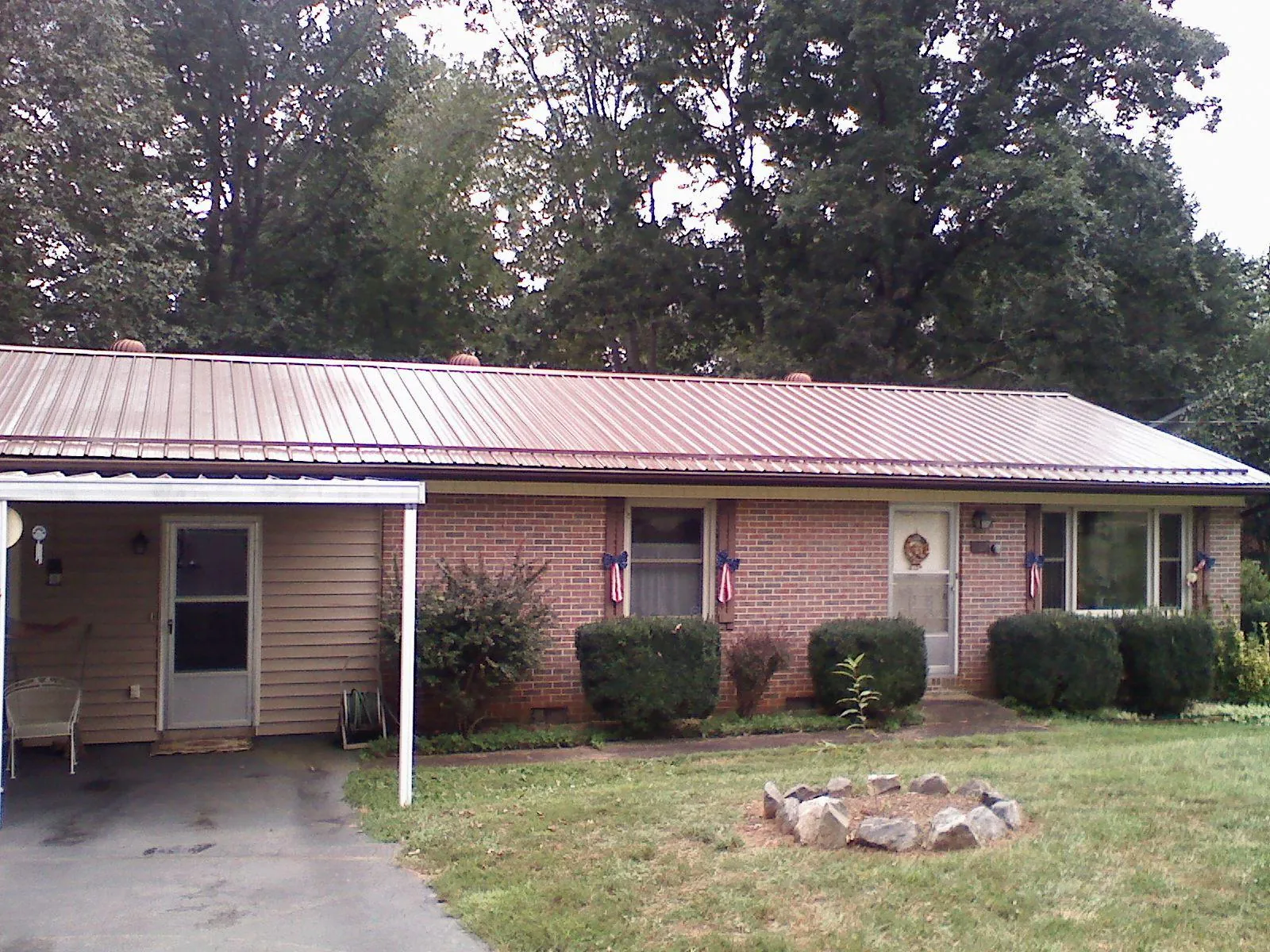 Bronze metal roof and carport on a brick ranch home — Roof Repair work by our crew in Akron